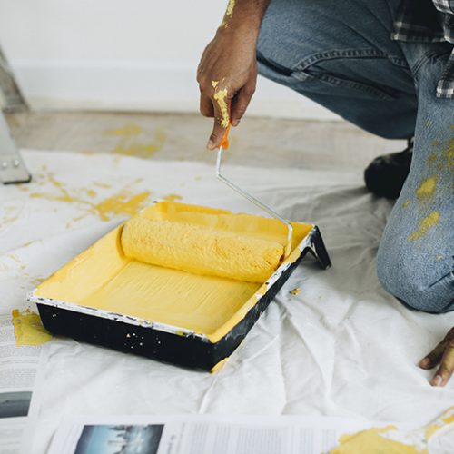 Man painting the walls yellow